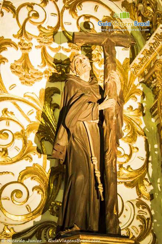 Imagem de santo com crucifixo ao lado, no altar da igreja.