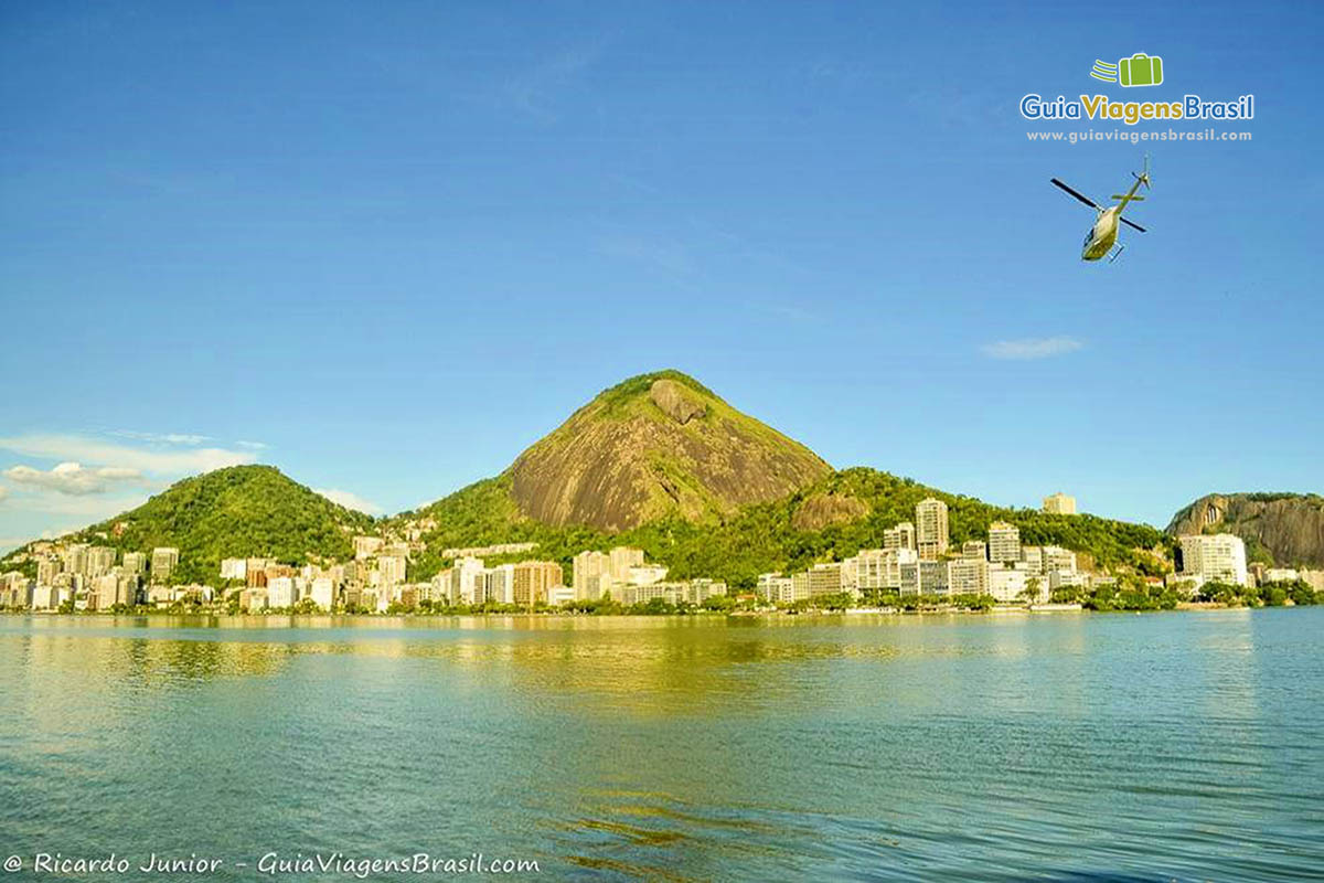 Imagem de um helicóptero no céu do Rio e a belíssima Lagoa Rodrigo de Freitas.