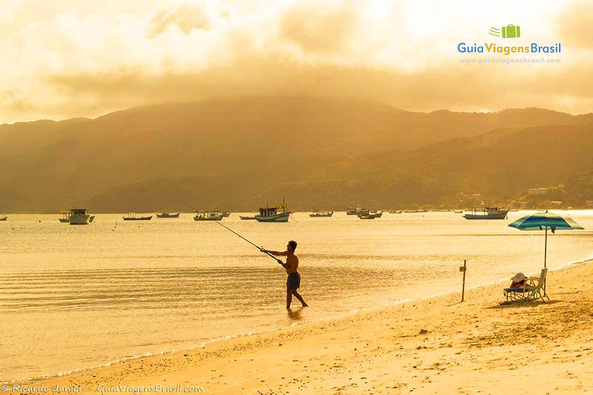 Imagem de uma pessoa pescando nas águas da Praia Canto Grande.