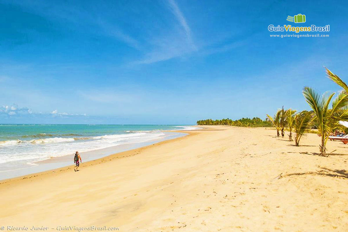 Image de turistas caminhando na beira da Praia Rio da Barra.