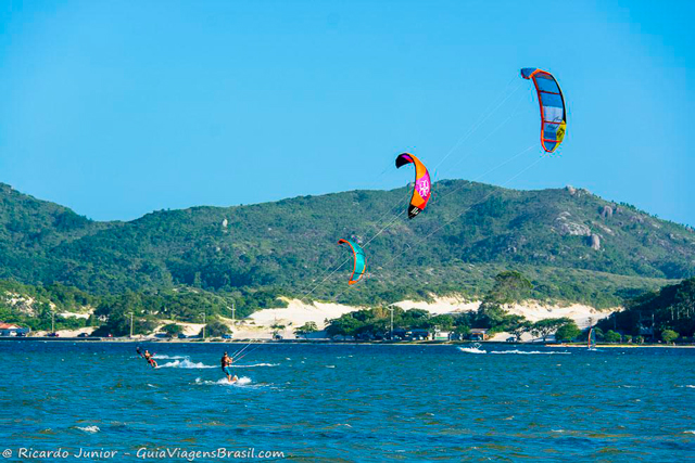 Iniciantes e veteranos do kitesurf na Lagoa da Conceição, em Florianópolis. Photograph by Ricardo Junior / www.ricardojuniorfotografias.com.br