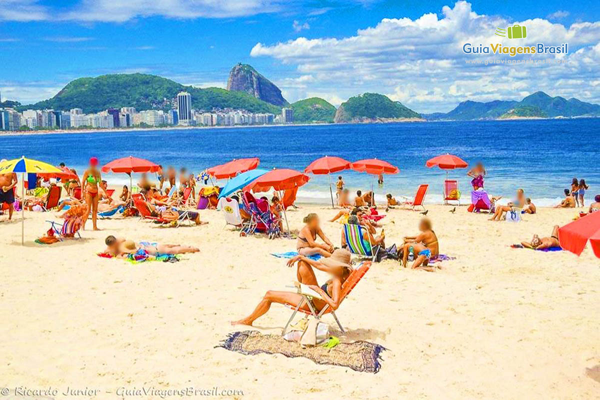 Foto turistas curtindo dia de sol na Praia de Copacabana, Rio de Janeiro, RJ.