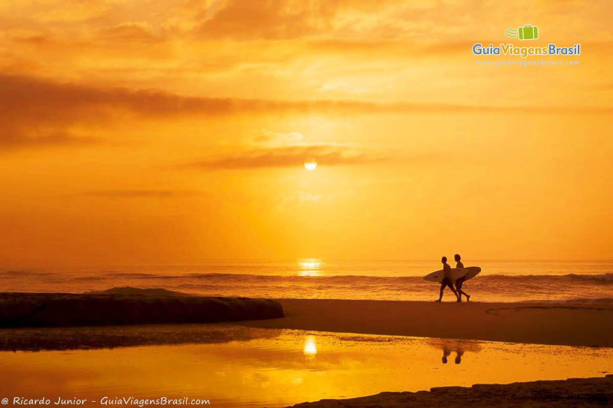 Foto surfistas ao pôr do sol na Praia Brava, Itajaí, SC.