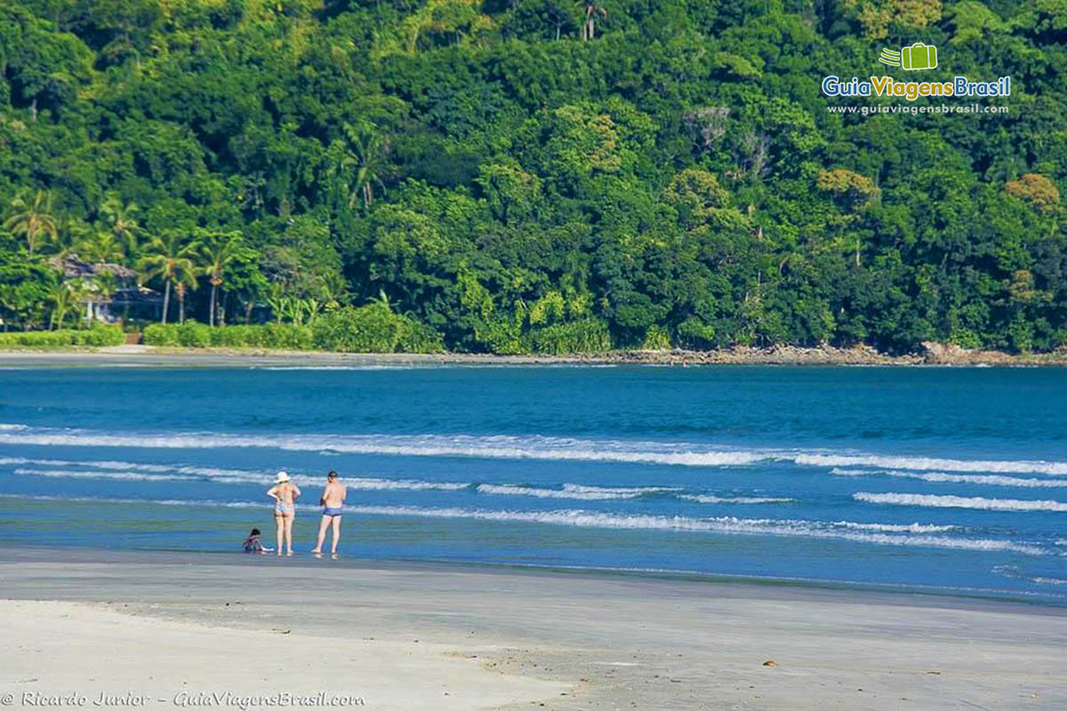 Foto pessoas caminhando na Praia da Baleia, São Sebastião, SP.