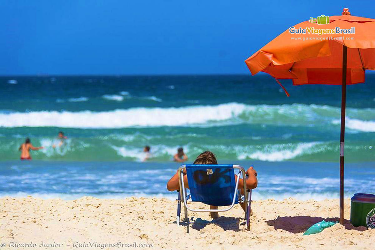 Foto turista e mar na Praia do Campeche, Florianópolis, SC.