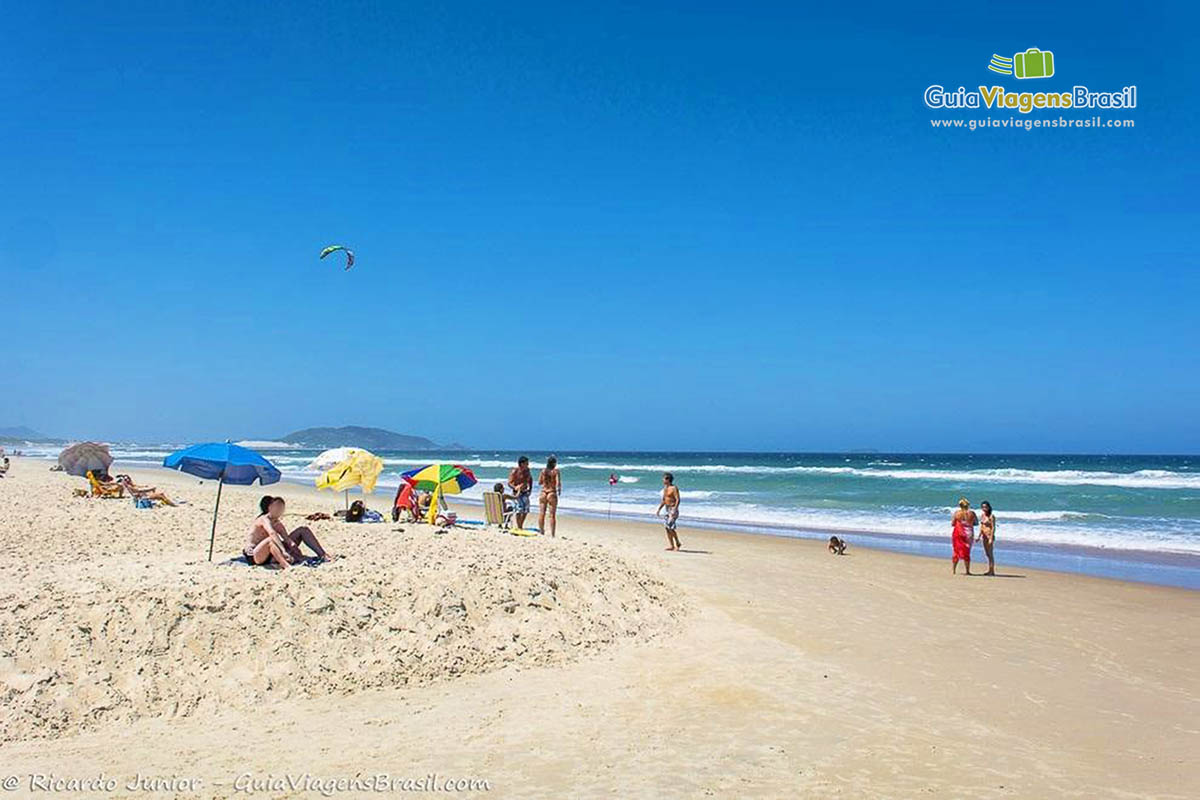 Foto turistas na orla da Praia do Campeche, Florianópolis, SC.