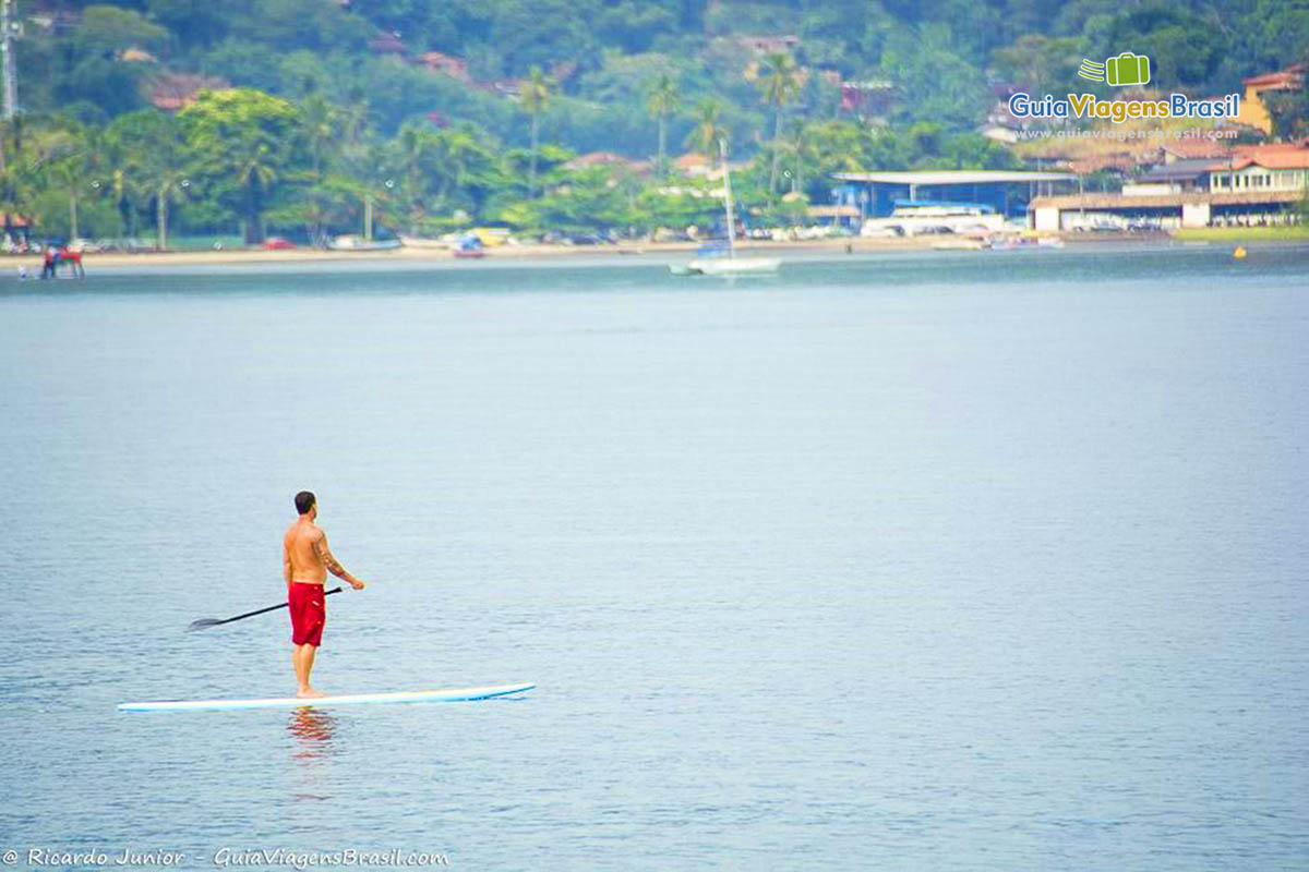 Foto praticante de stand-up-padlle na Praia de Perequê, em Ilhabela, SP.