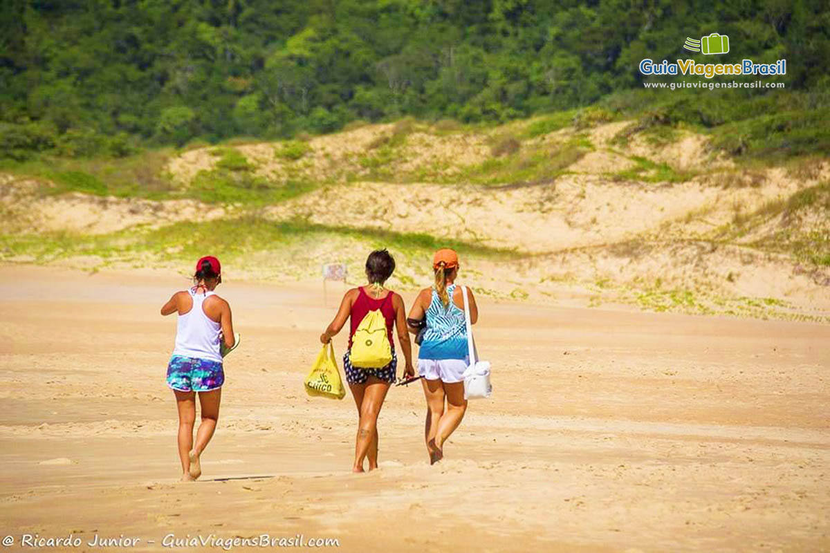 Imagem de três amigas caminhando nas areias da Praia Lagoinha do Leste.