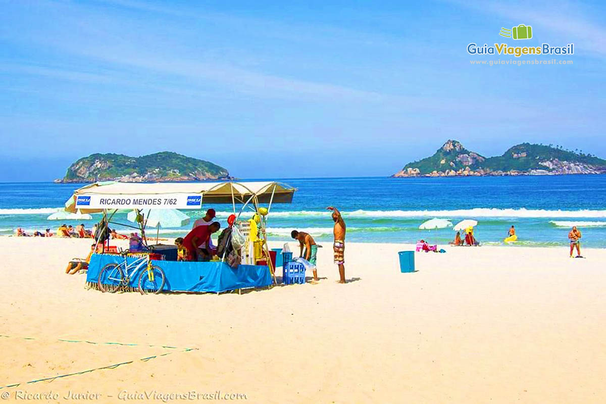 Imagem de amigos se encontrando  na barraca da Praia da Barra da Tijuca.