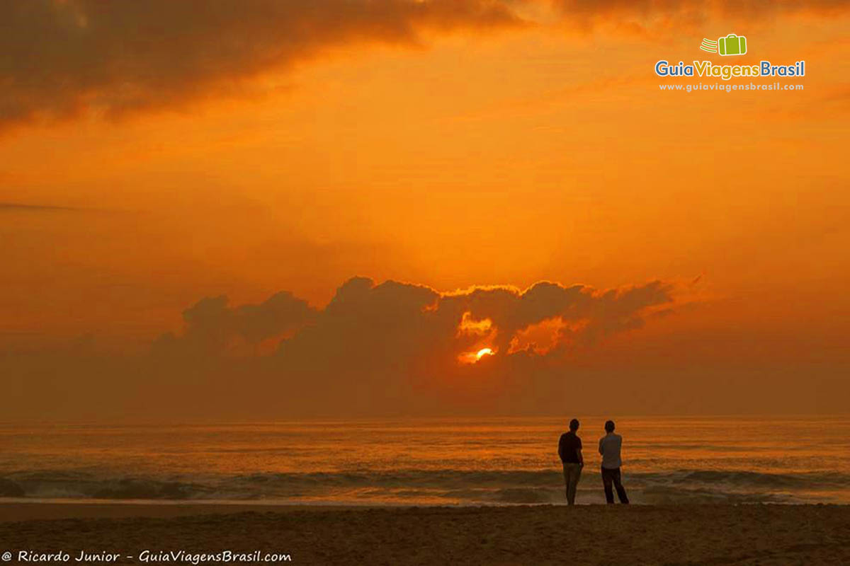 Imagem de amigos admirando  admirando o lindo entardecer.