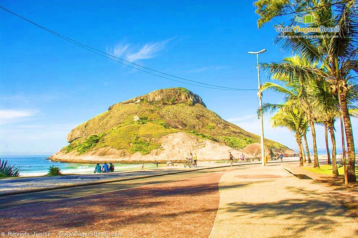 Imagem de amigos sentados na orla da praia.