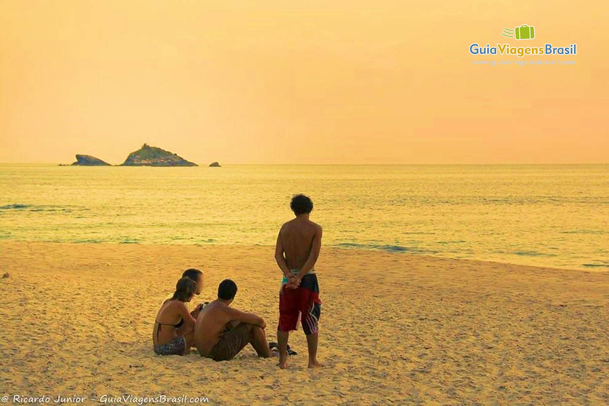 Imagem de amigos no entardecer na Praia Santiago.