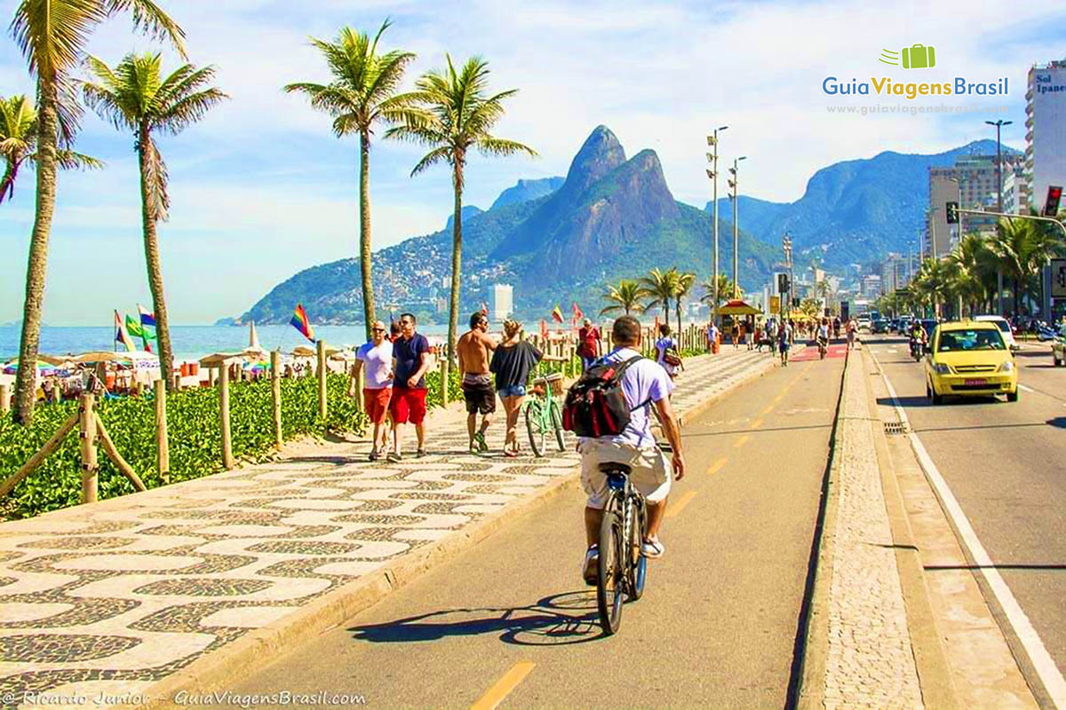 Imagem de uma pessoa andando de bicicleta na ciclovia de Ipanema. 