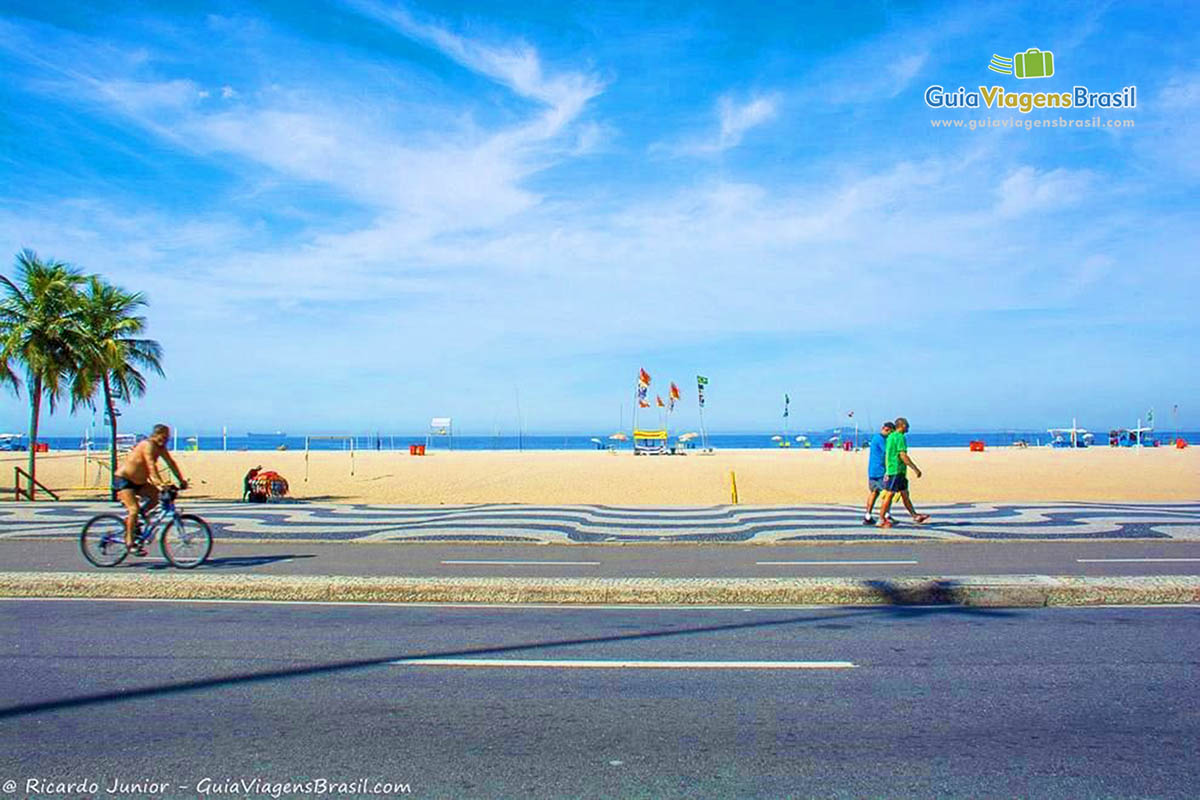 Imagem de uma pessoas andando no calçadão da Praia Leme.
