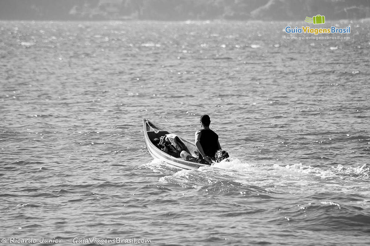 Imagem de uma pessoa andando de barco na Lagoa da Conceição.