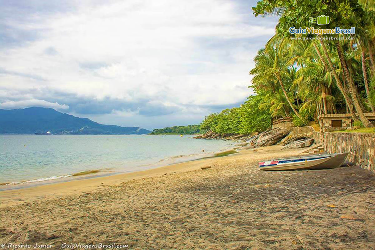 Imagem de um barco nas areias da Praia do Veloso em Ilhabela.