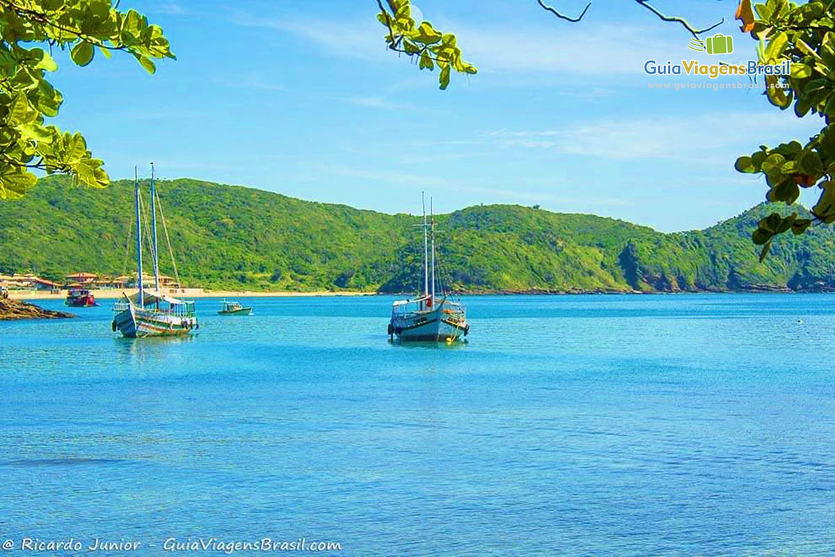 Imagem de uma dia ensolarado com barcos no mar da praia em Búzios.