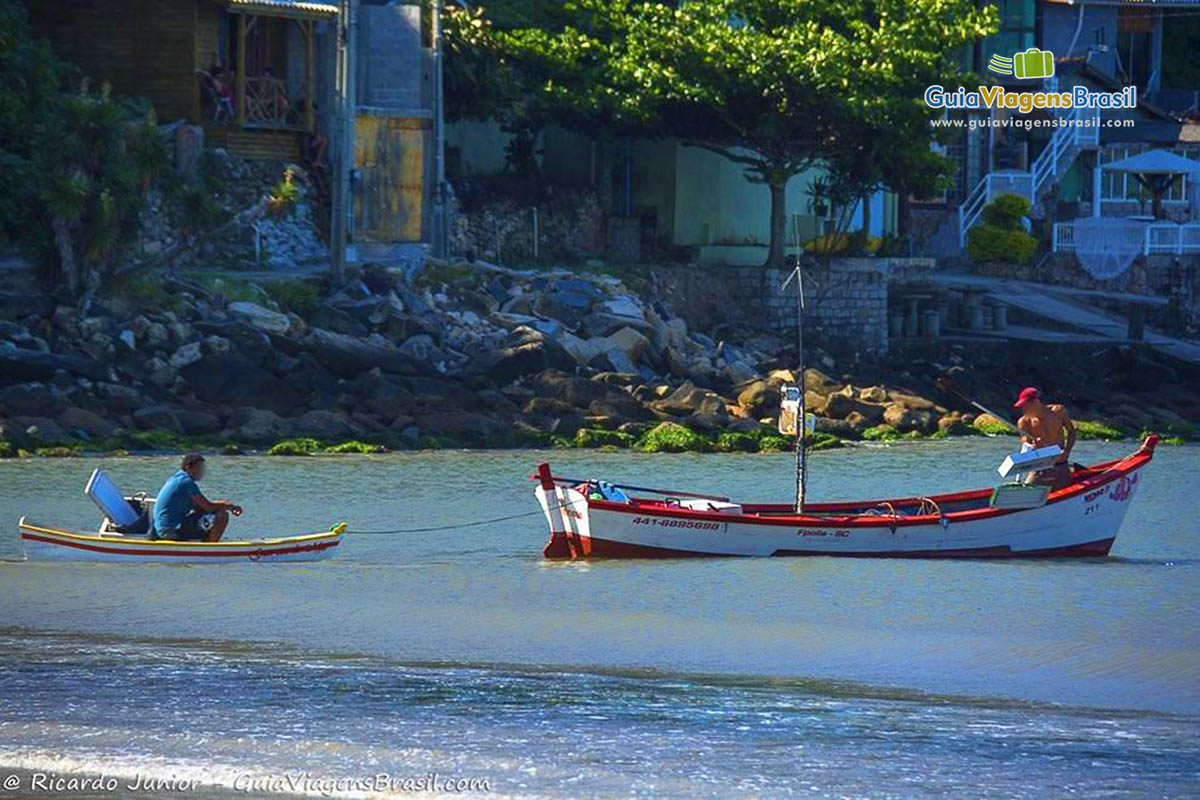 Imagem de pescadores dentro do barco saindo para pescar.