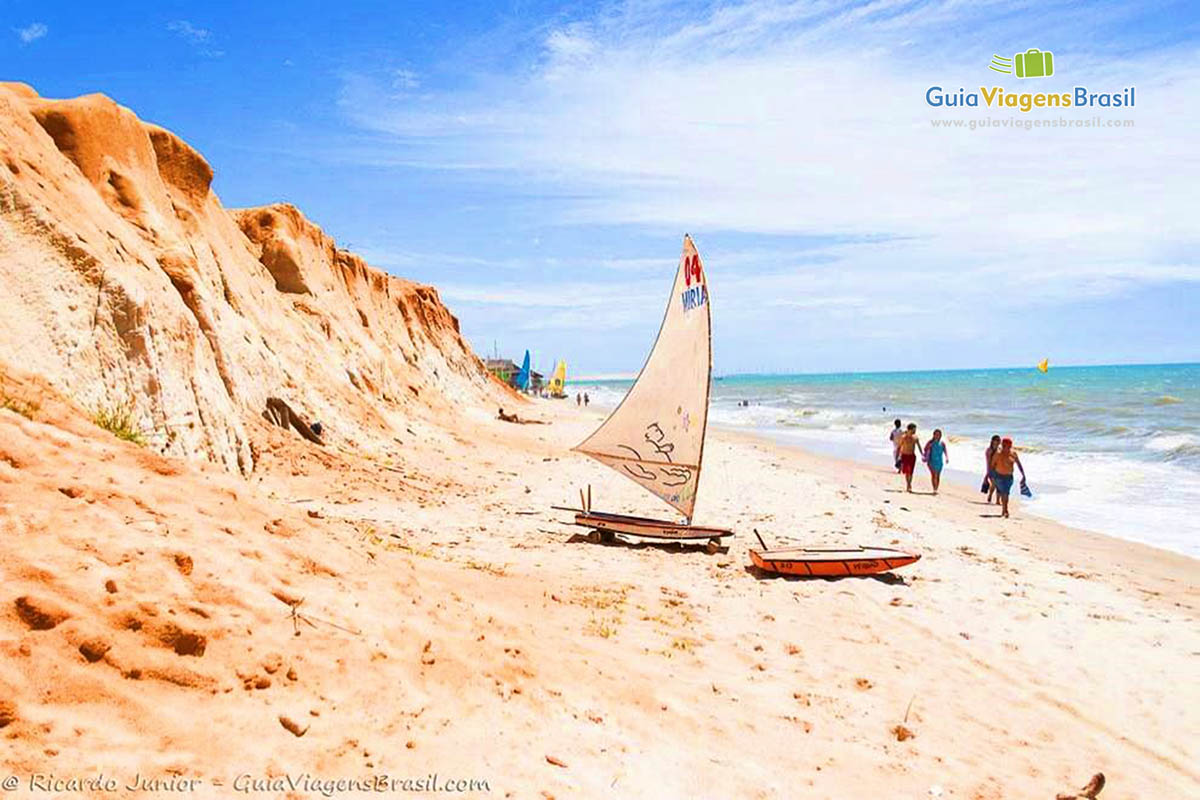 Imagem de barco a vela nas areias da praia.