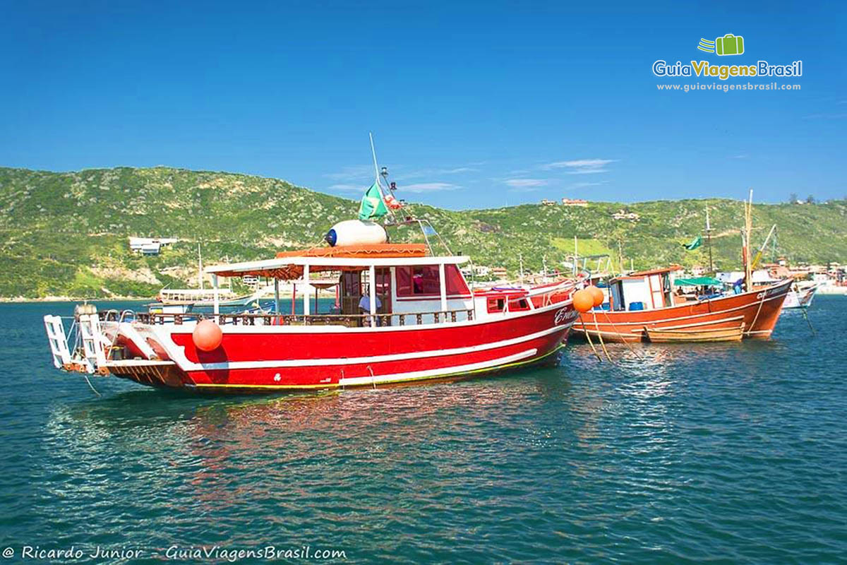 Imagem de barco vermelho na praia.