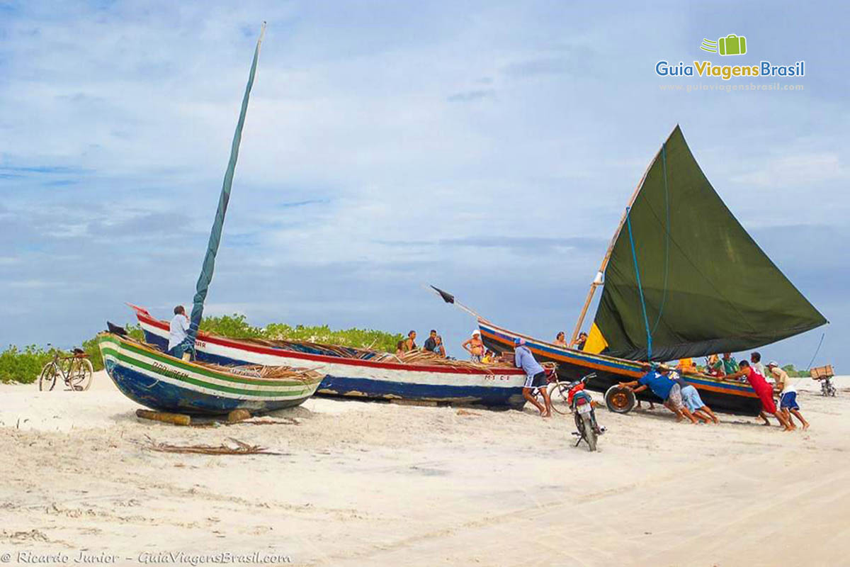 Imagem de barcos na areia.