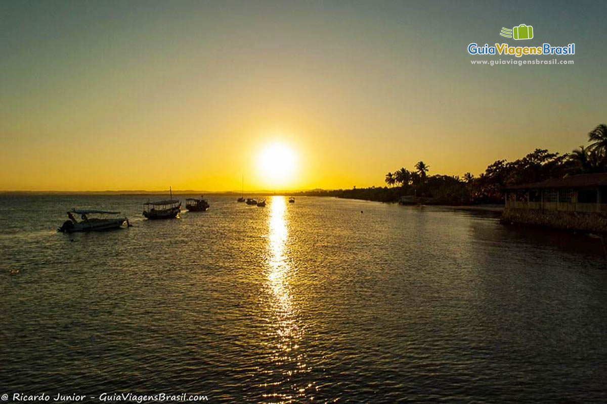 Imagem de barcos de pescadores no mar e ao fundo lindo por do sol na travessia para Morro São Paulo.