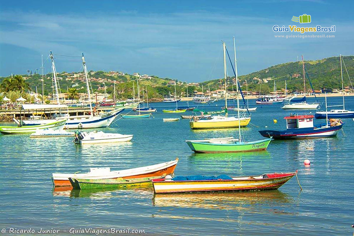 Imagem de vários barcos coloridos de pescadores no mar da Praia dos Ossos.