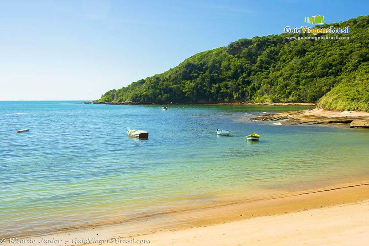 Imagem de barquinhos simples no mar da Praia Tartaruga.