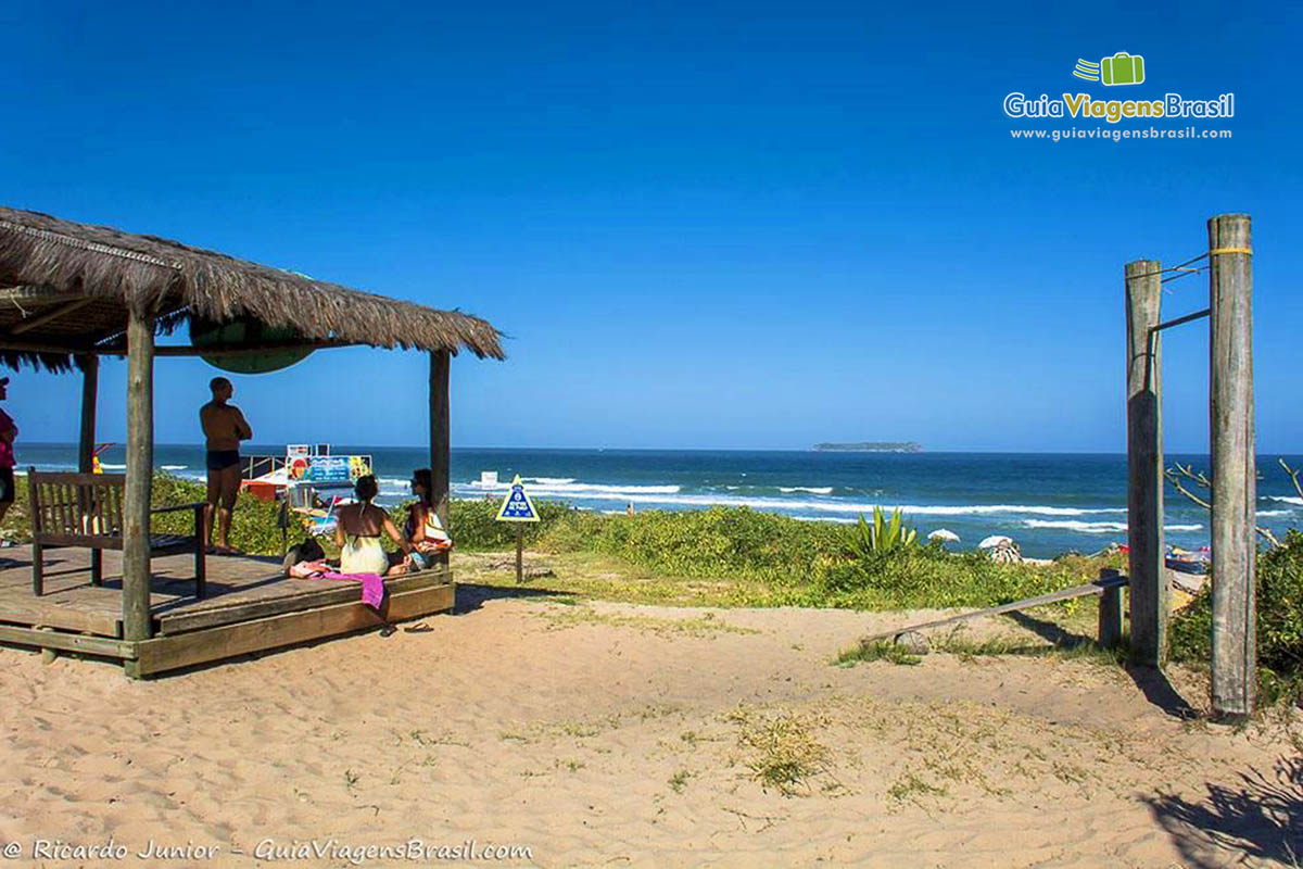 Imagem de barraca de sapê e ao fundo a Praia Mole.