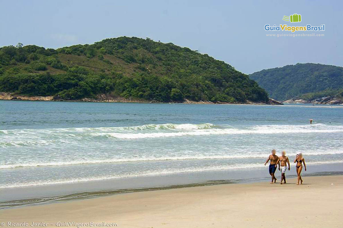 Imagem de amigos caminhando na beira da Praia de Pernambuco.