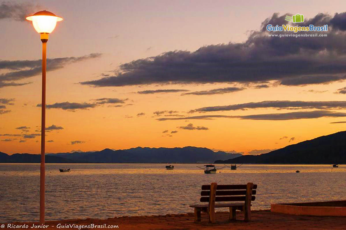 Imagem banco e lindo entardecer na Praia Canto Grande.