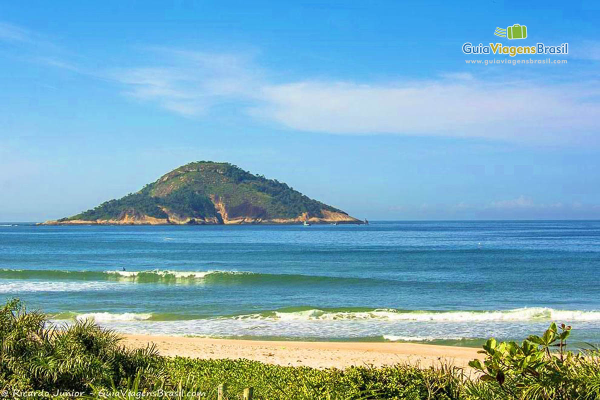 Imagem da Praia Prainha com uma pequena ilha no mar.