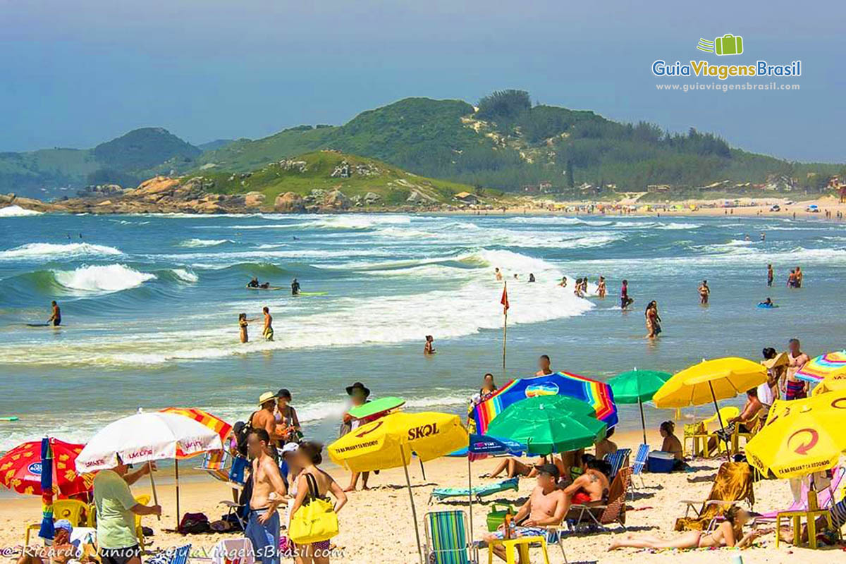 Imagem da areia repleta de turistas na Praia Ferrugem, em Garopaba.