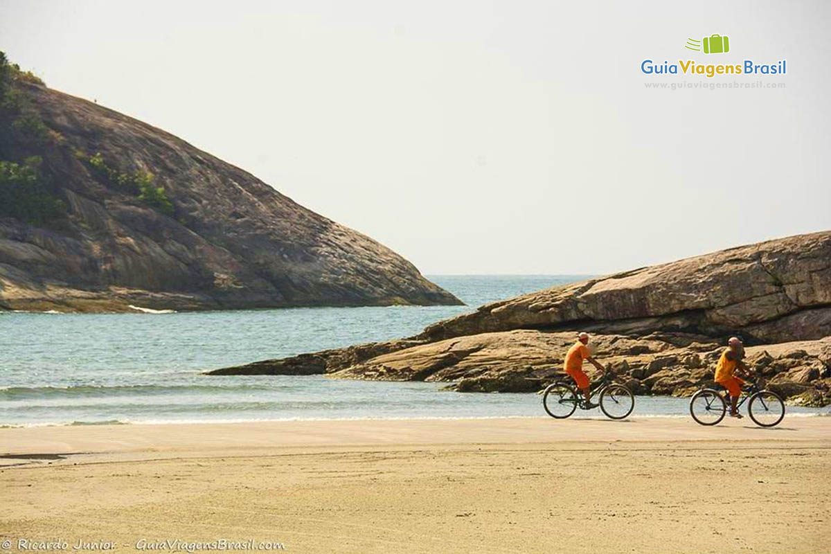 Imagem de dois rapazes andando de bicicleta pela Praia de Pernambuco.