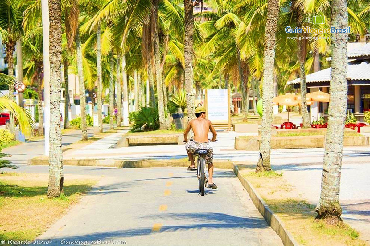 Imagem de um rapaz andando de bicicleta na ciclovia da Praia Grande.