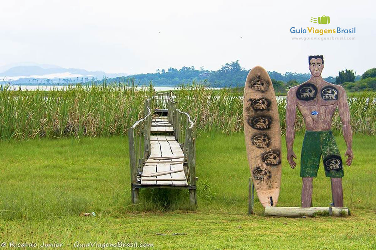 Imagem de madeira de um surfista na chegada da Praia Barra de Ibiraquera.