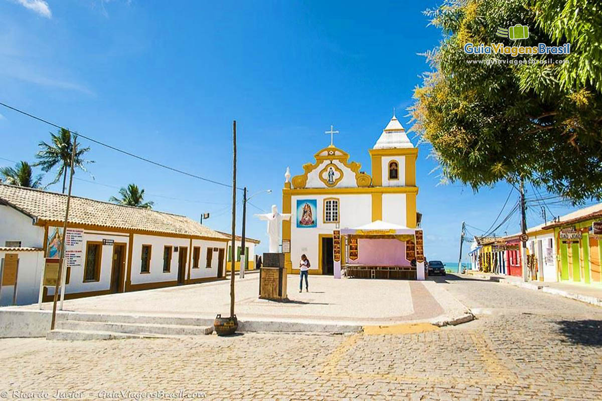 Imagem da praça e ao fundo a igreja no centro de Arraial.