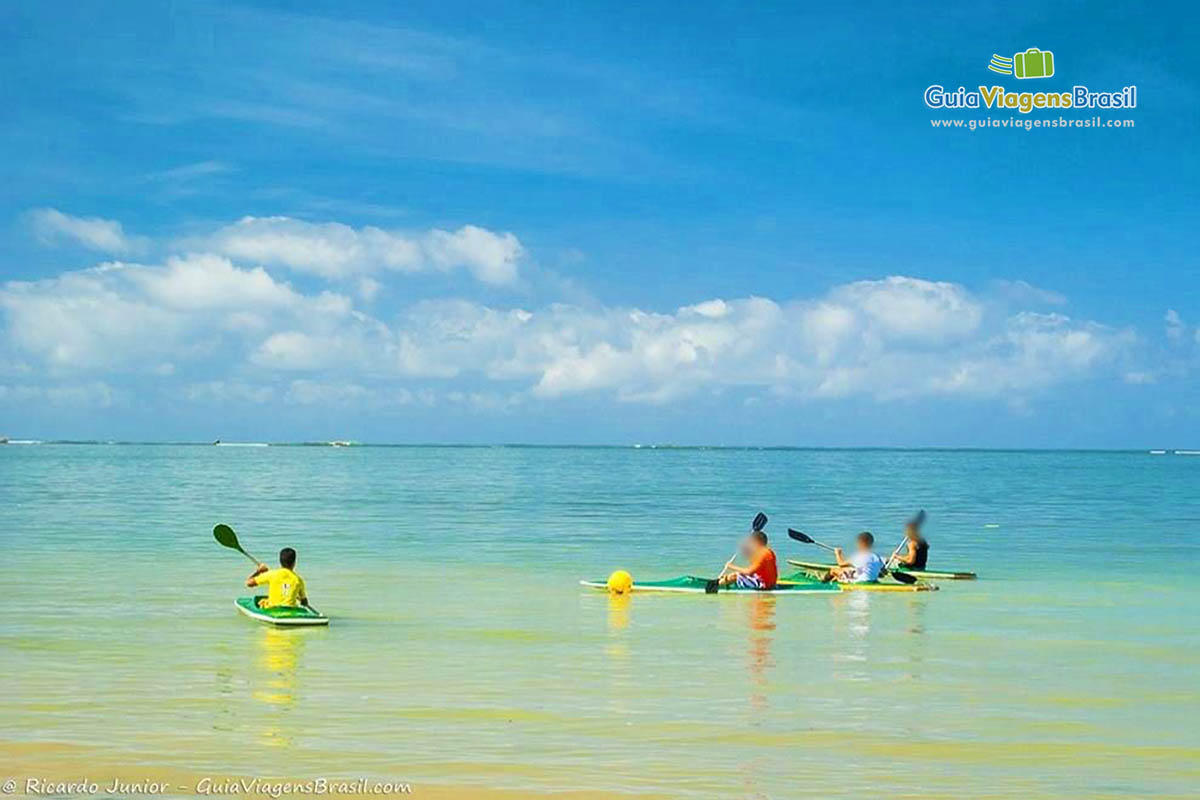 Imagem de amigos de caiaque no mar.