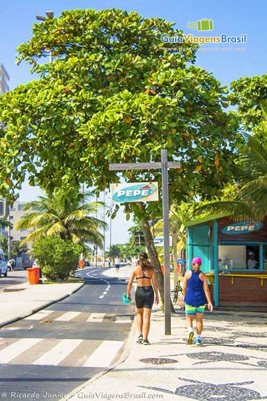 Imagem de duas amigas caminhando no calçadão.