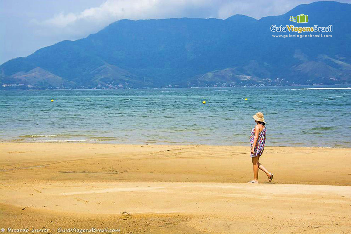 Imagem de uma pessoa caminhando na linda Praia do Sino.