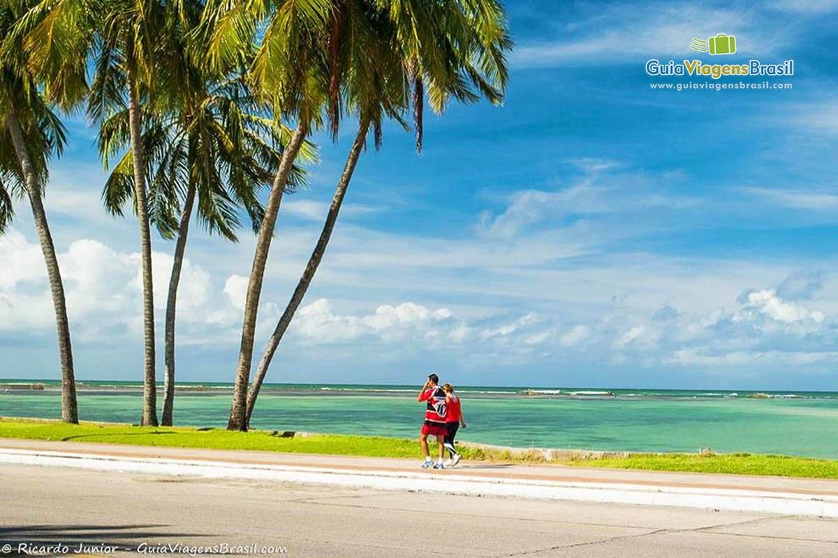 Imagem de casal caminhando pela linda orla da Praia Ponta Verde.