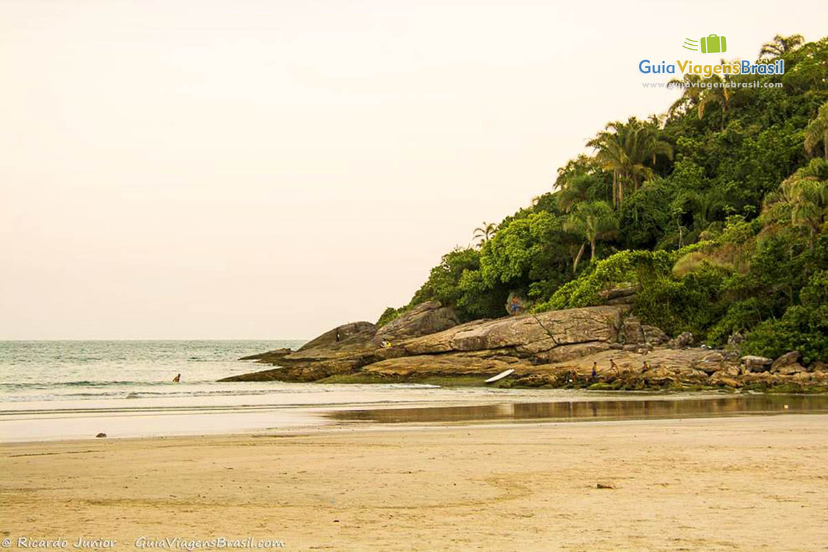 Imagem do canto da praia com belas pedras.