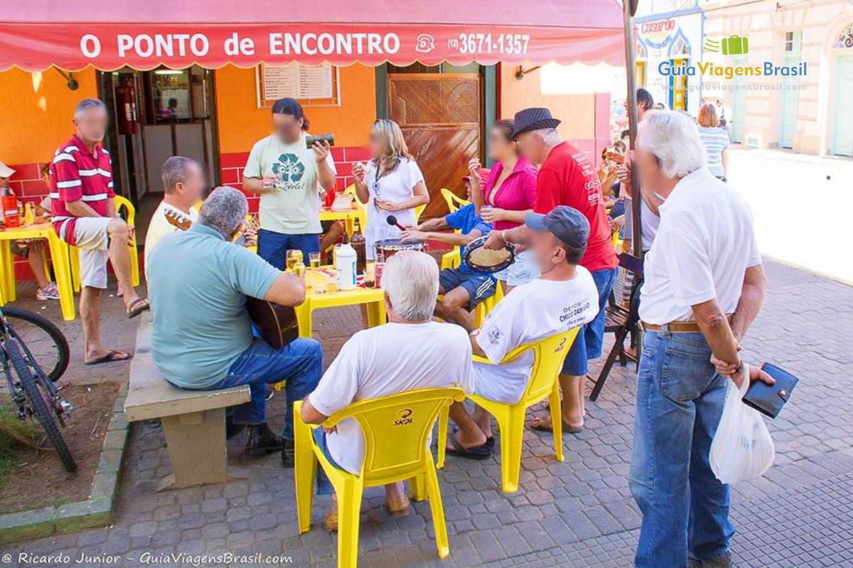 Imagem de músicos reunidos em um bar.