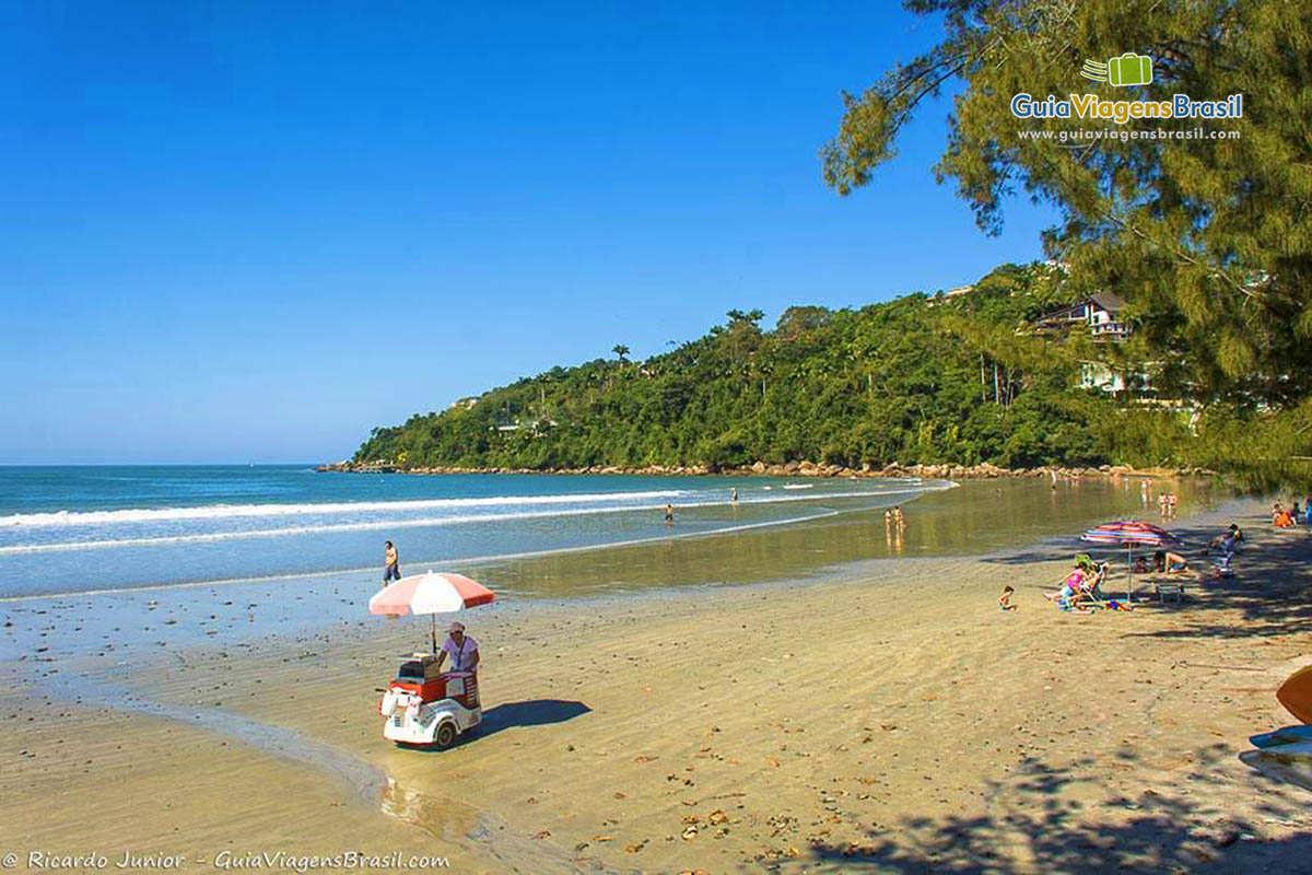 Imagem de sorveteiro andando nas areias da Praia das Toninhas.