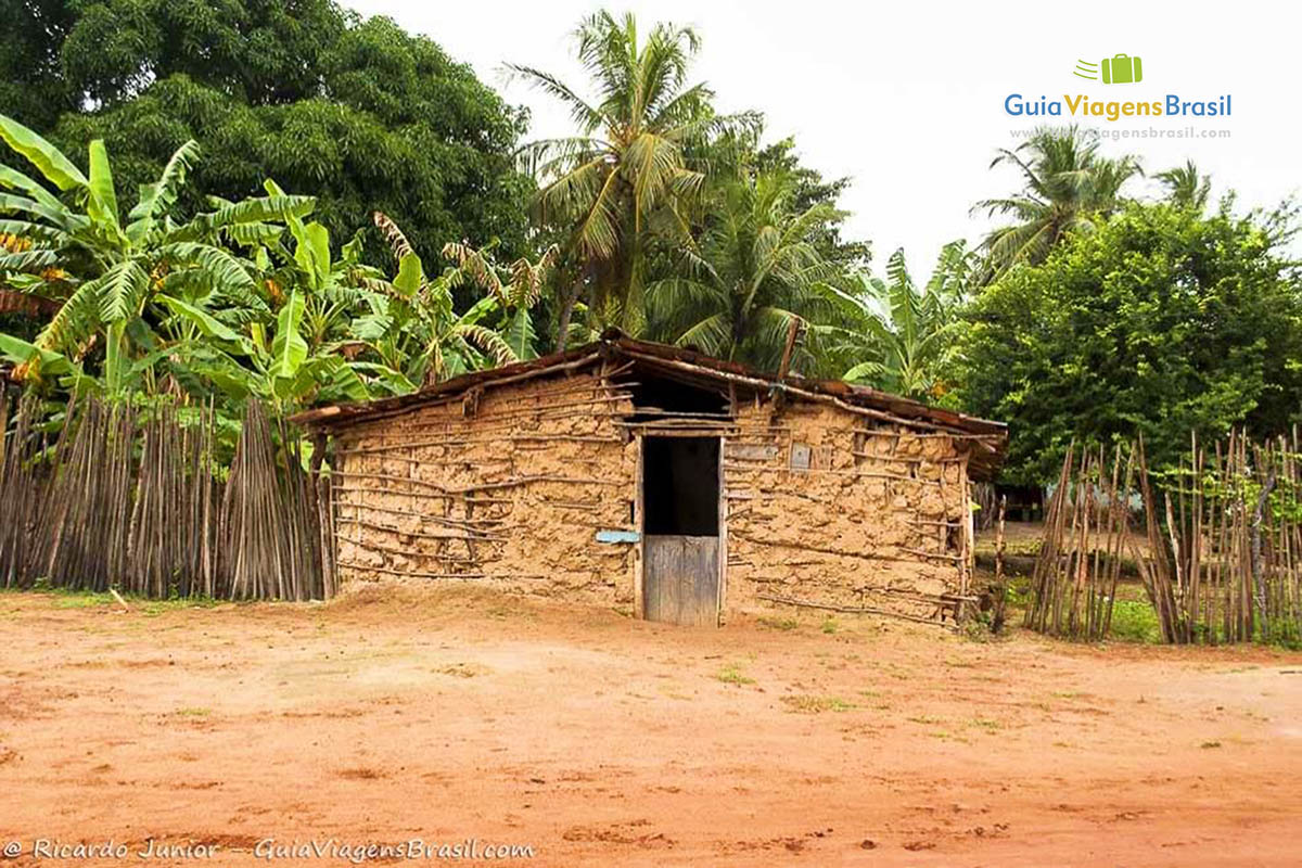 Imagem de casa de barro e ao fundo árvores na Praia do Marco.