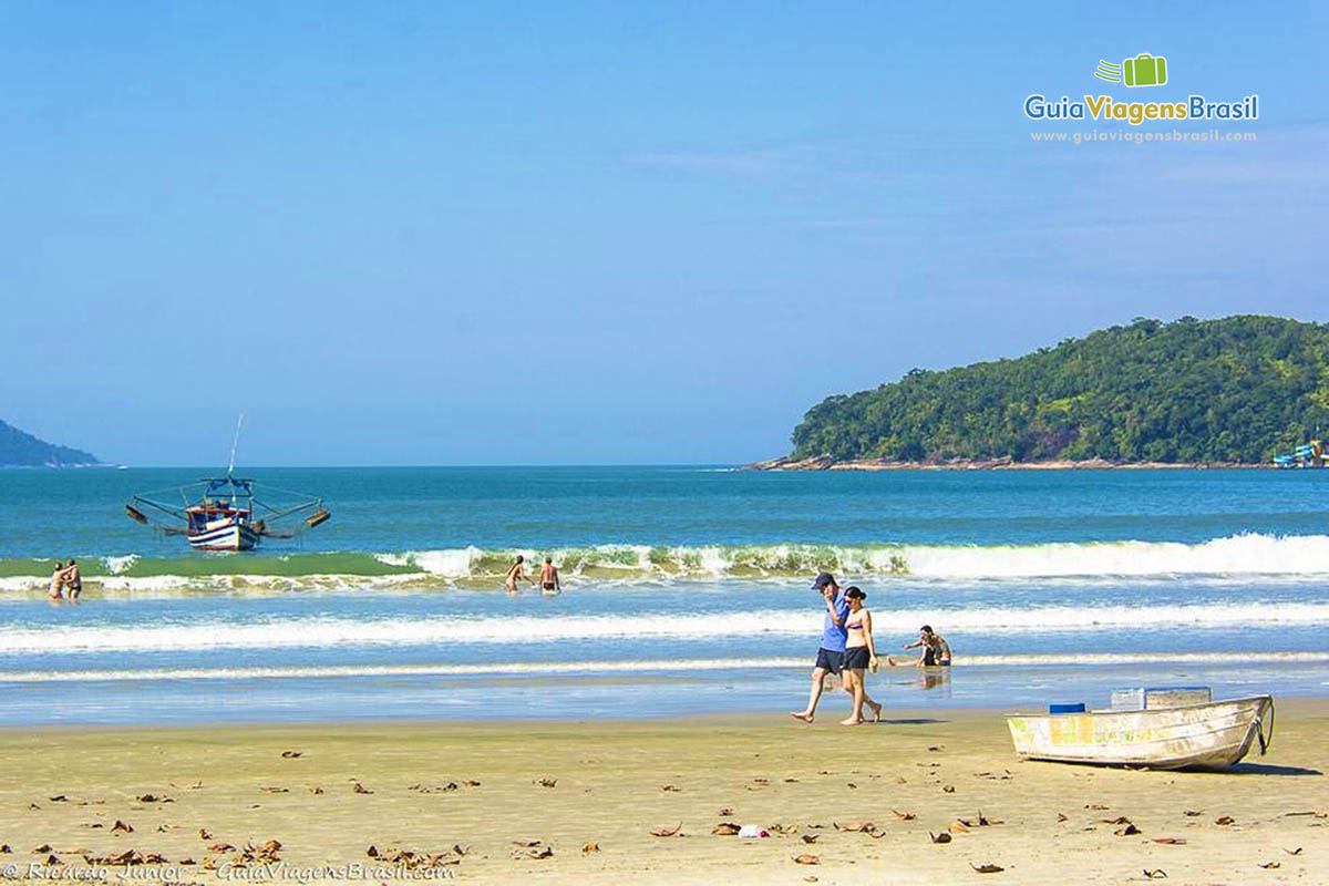 Imagem de casal fazendo caminhada na beira do mar da Praia Maranduba.