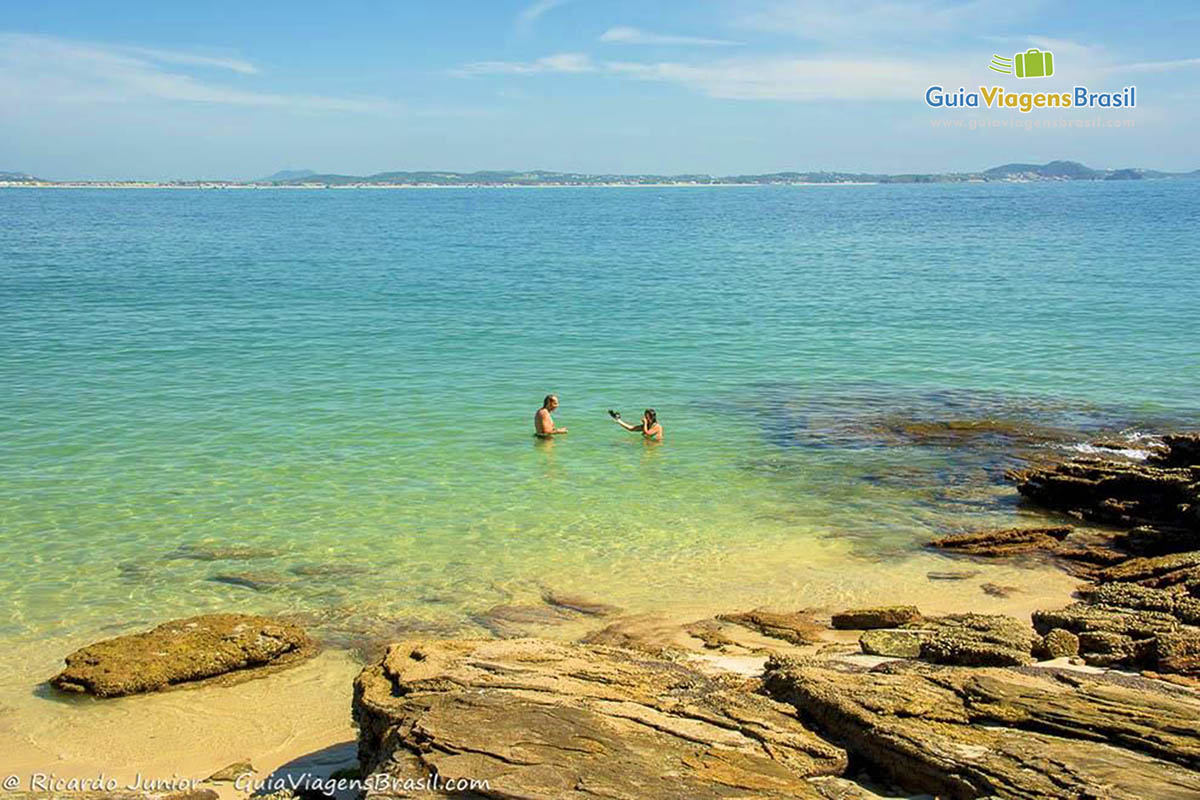 Imagem de casal nas águas da bela praia.