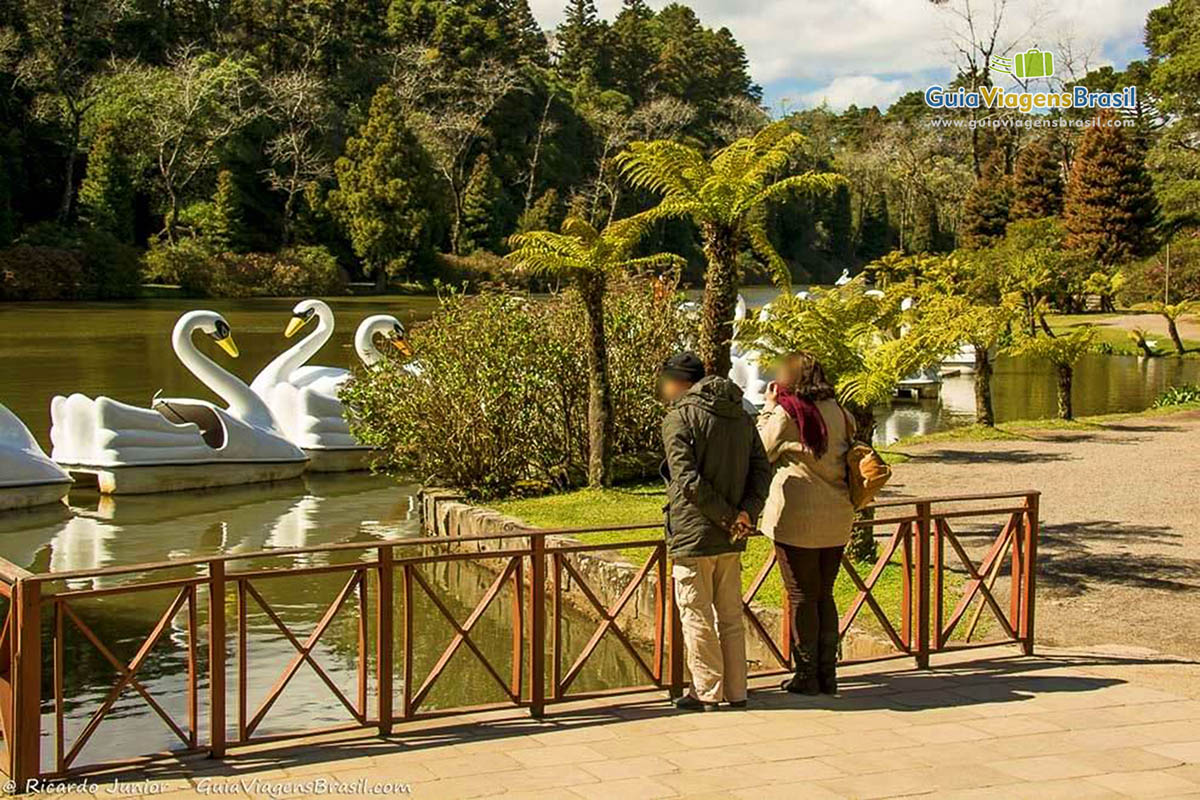 Imagem de casal olhando para Lago com pedalinhos.