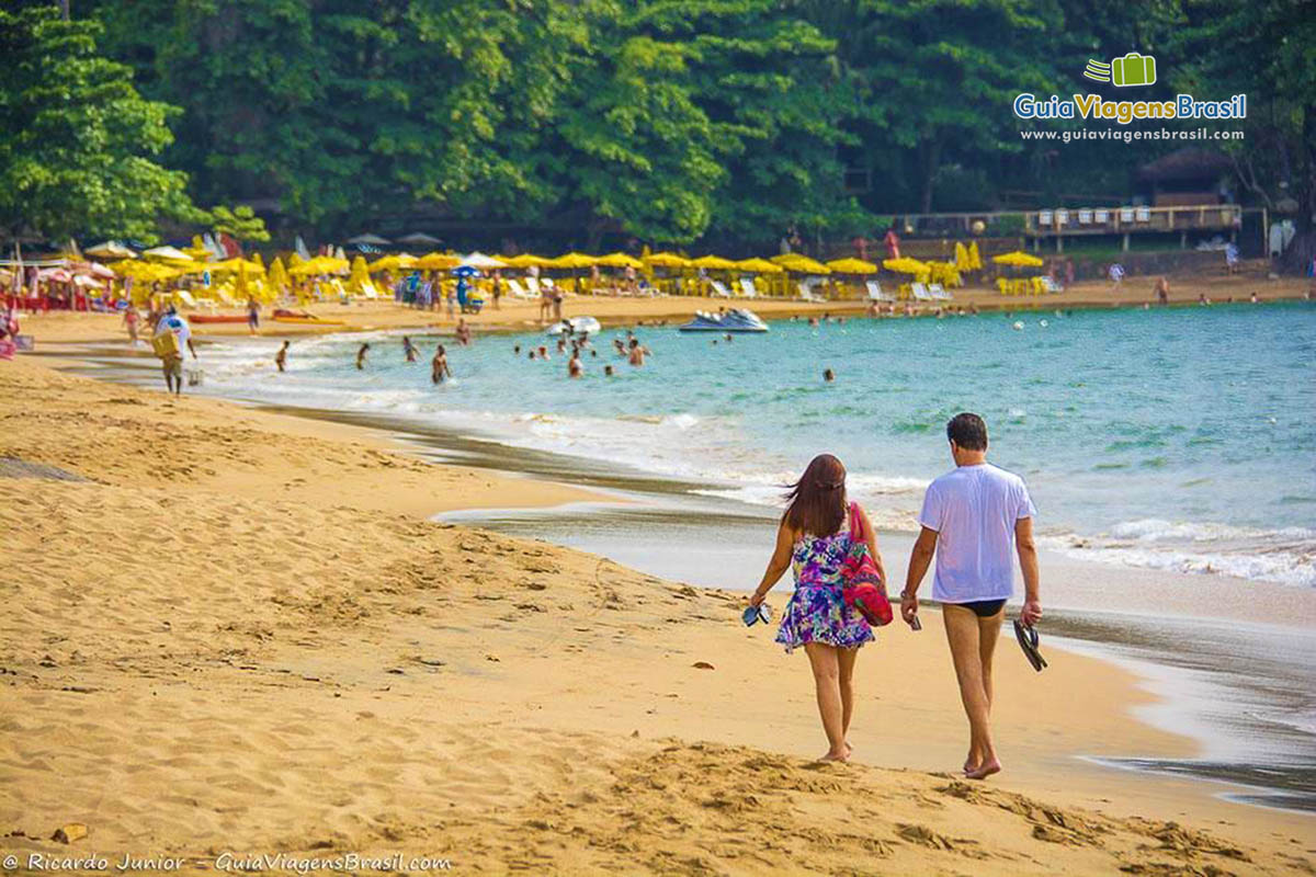 Imagem casal caminhando pela linda praia.
