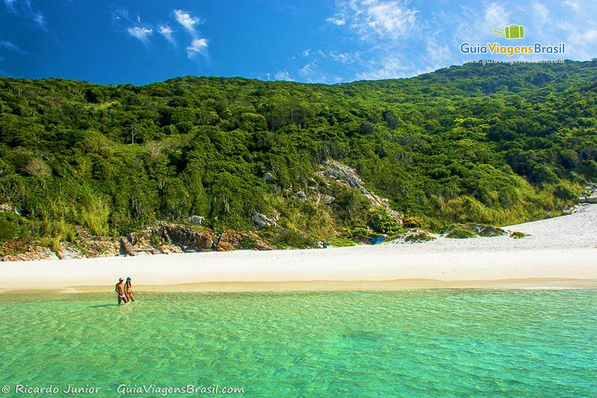 Imagem de casal caminhando na lindíssima Praia Pontal do Atalaia.